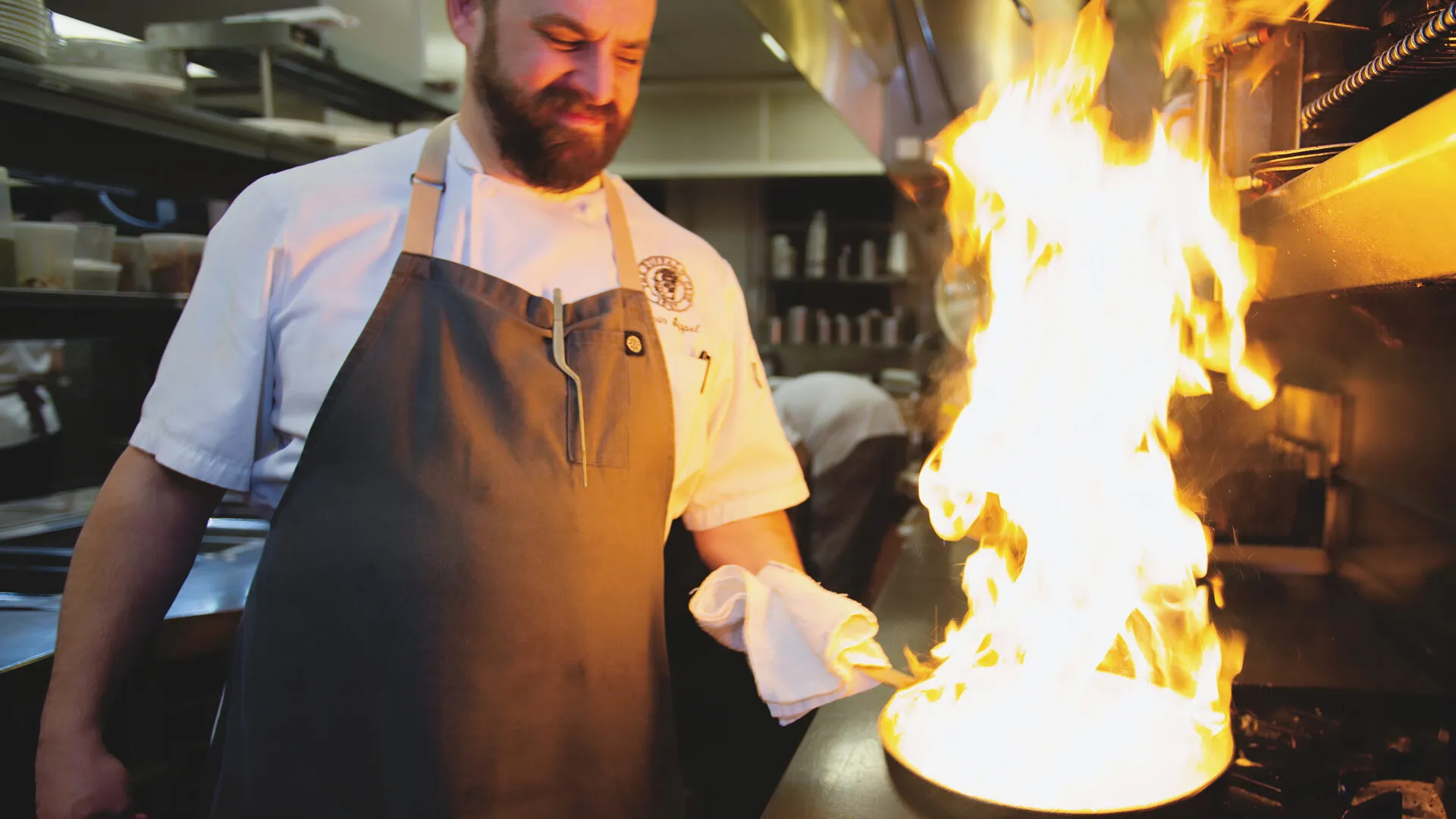Chef flambéing a dish in the kitchen