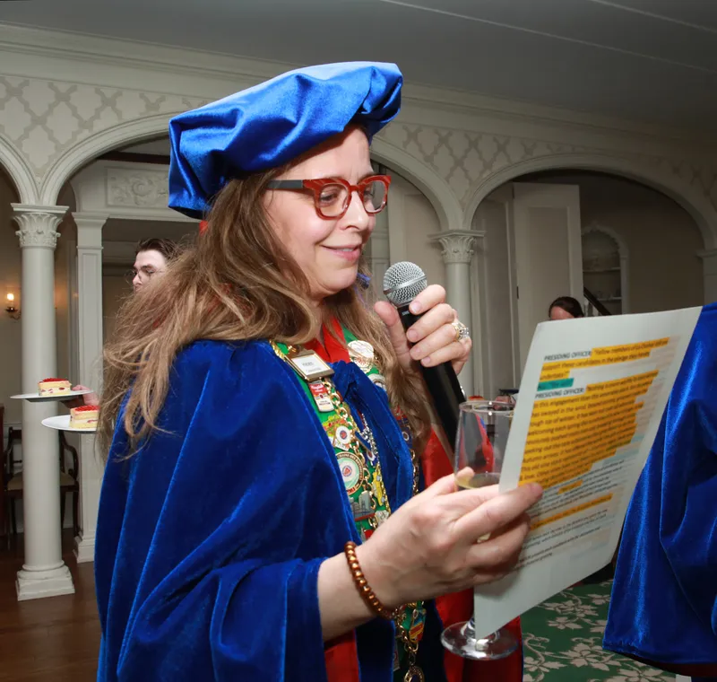 Newly invested Bailli in ceremonial blue cap reading the induction script