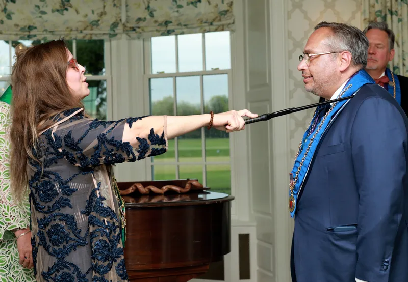 The shoulder-tap moment of the induction ritual