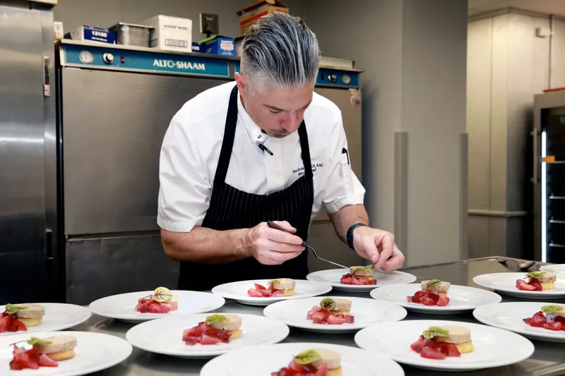 Chef Piazza completing the final course plates before service