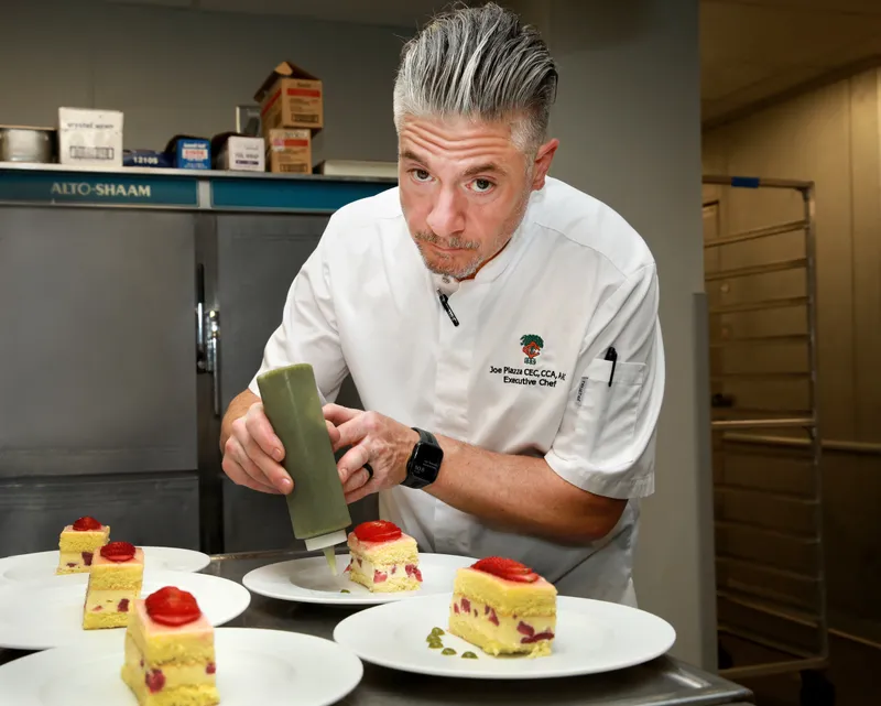 Chef Piazza dressing the fraisier cake with basil sauce