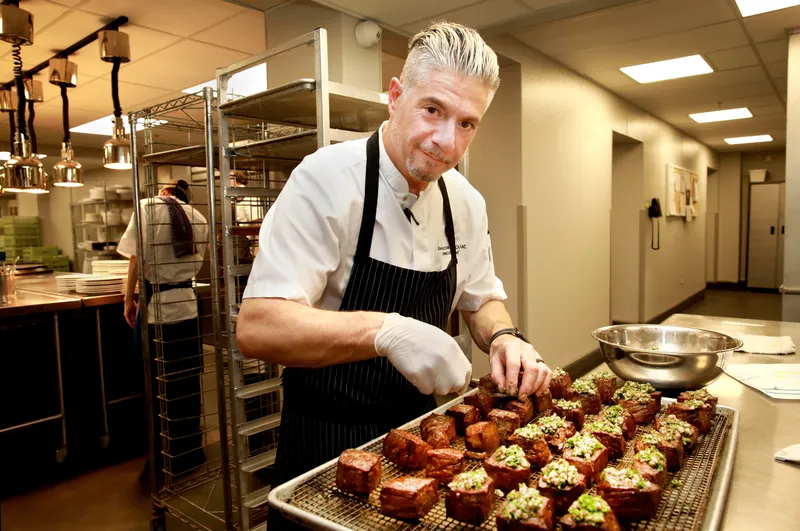 Chef Piazza plating wagyu cubes on the kitchen line