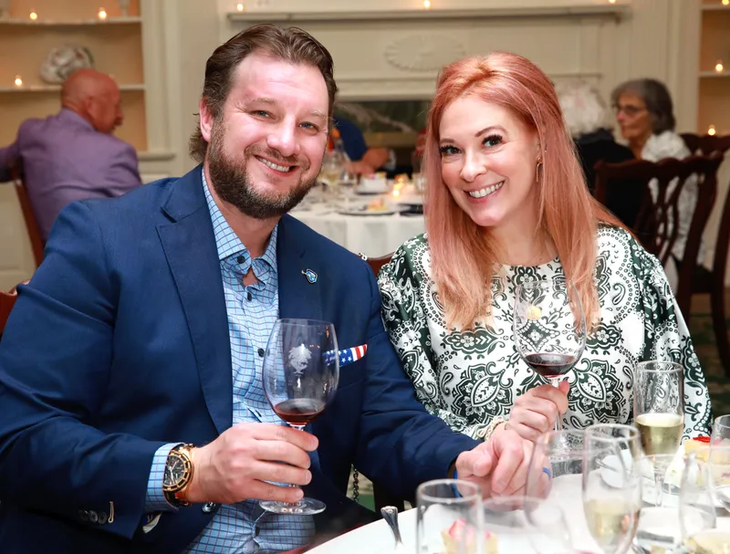 Couple raising wine glasses during dinner