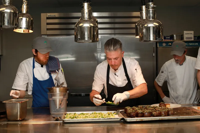 The kitchen team plating courses under the warming lamps