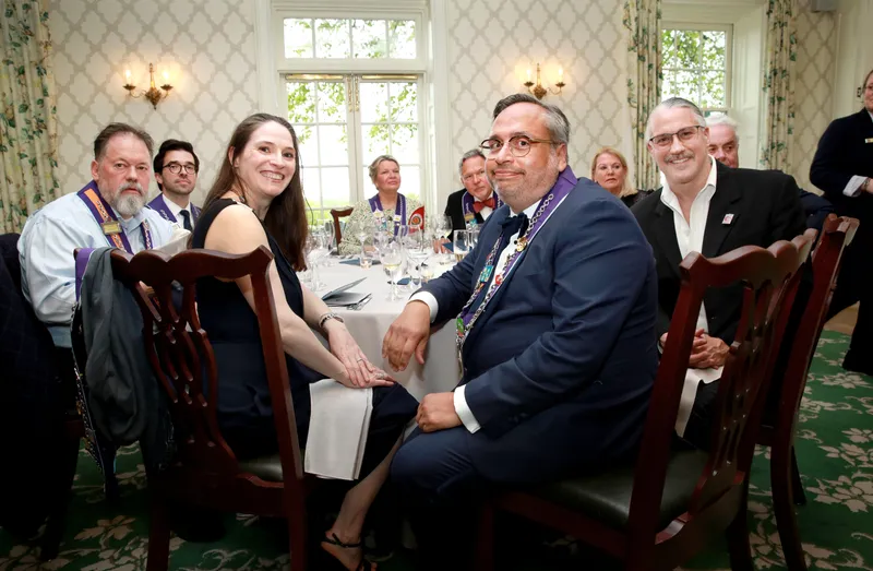 A table of five members in ribbons during dinner