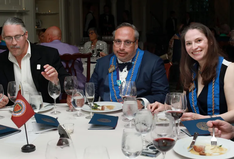 Three members seated together at their dinner table