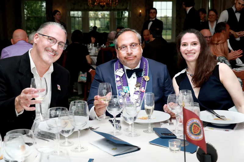 Three members raising glasses at their table
