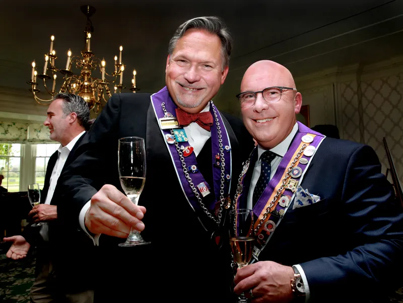 Two officers in ribbons sharing champagne at the reception
