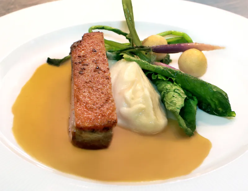 Crisp potato pavé with spring vegetables, mash and natural jus