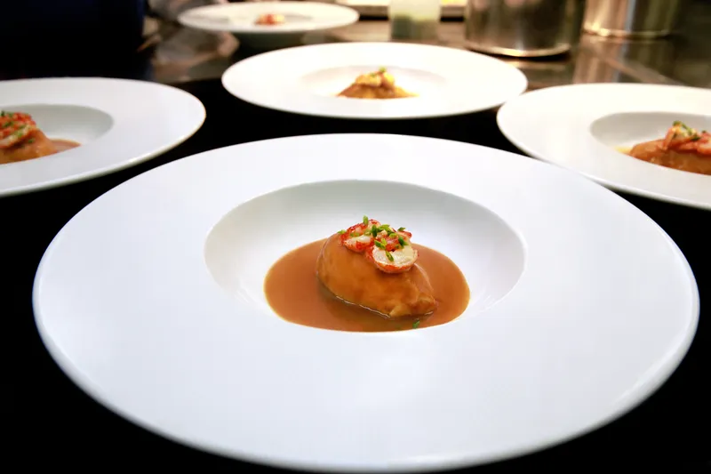 Quenelles topped with lobster waiting at the pass