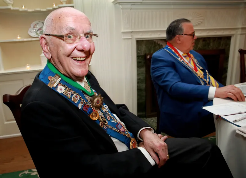 Longtime member smiling beside the fireplace