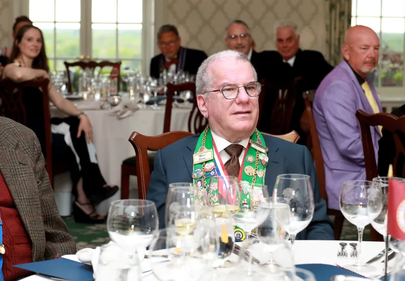 Member at his table beside the bailliage flag