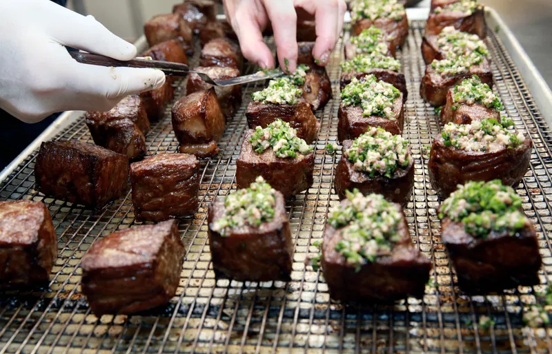 Wagyu strip loin cubes with marrow-and-herb crust resting on a rack