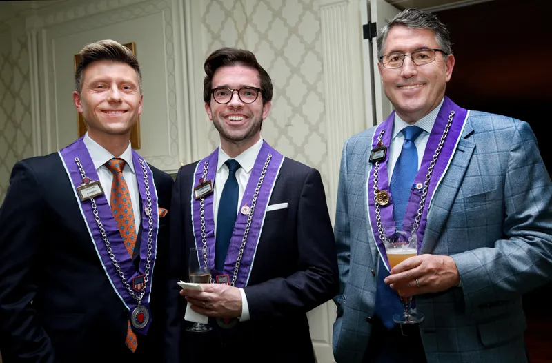 Three young officers in purple ribbons together at the reception