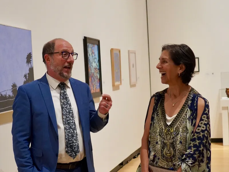 The guide chatting with a guest among the artworks
