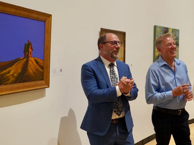 Members enjoying the gallery talk beside a painting