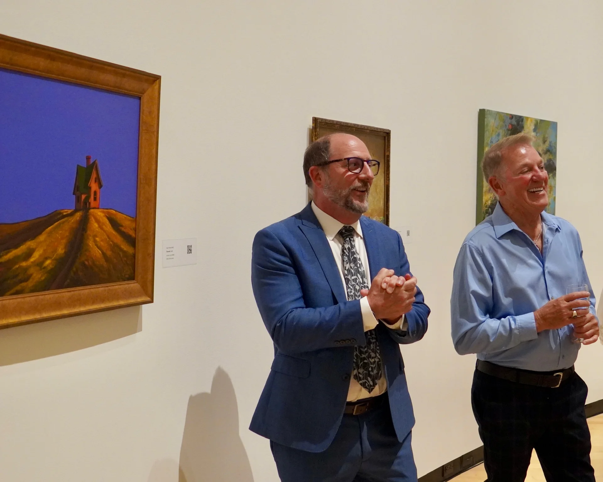 Members enjoying the gallery talk beside a painting