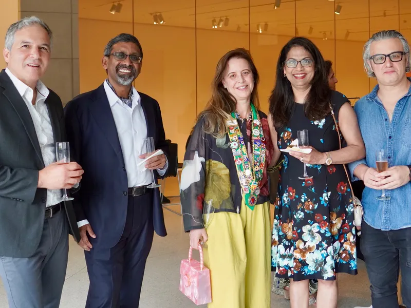 Five members gathered with drinks during the reception