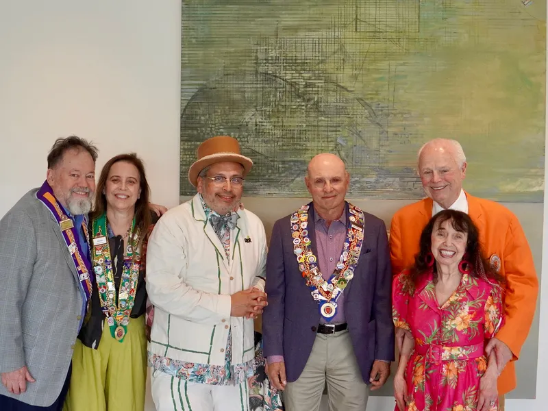 Members and officers gathered before a painting at the reception