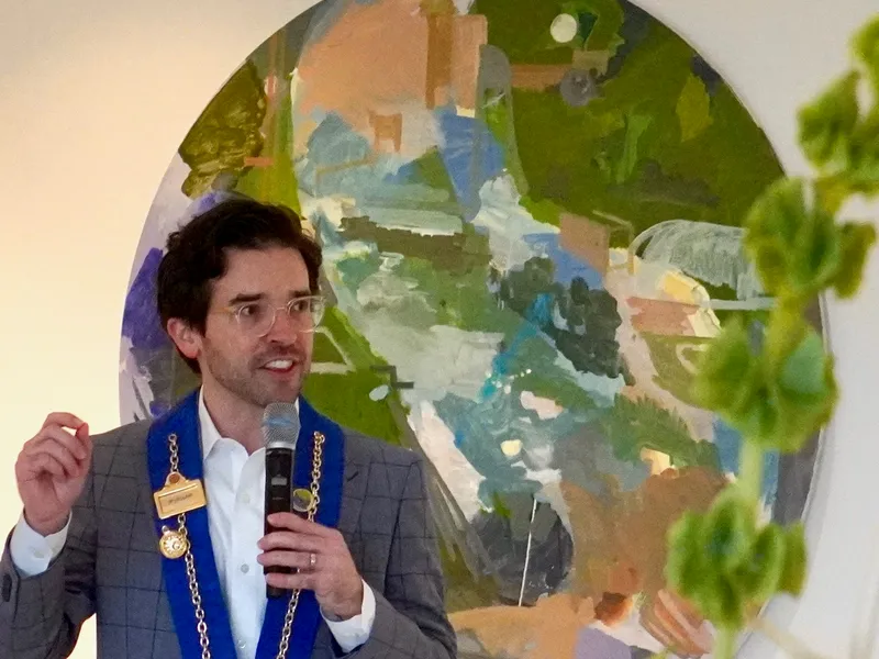 An officer addressing members before a circular painting