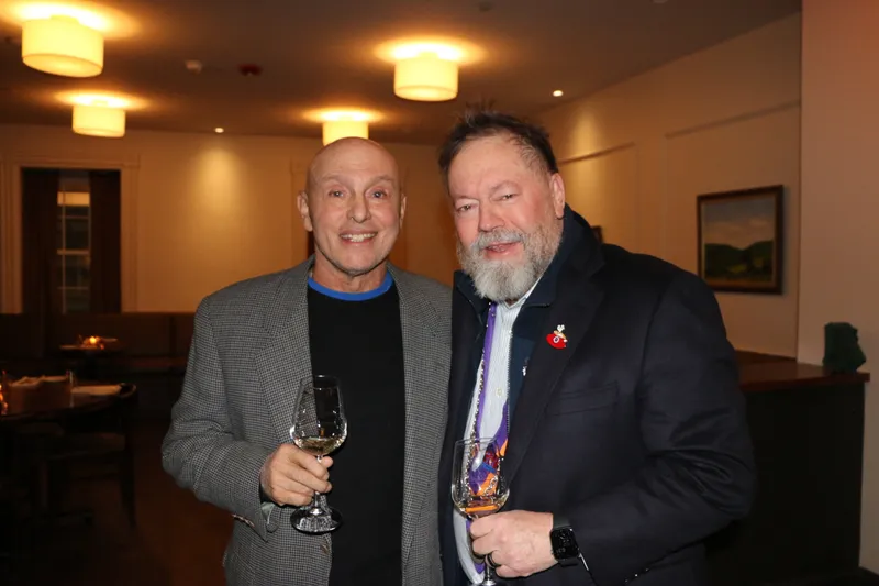Members with wine glasses in the dining room